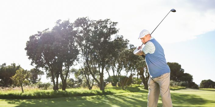 Golfer swinging on the grass on a sunny day at the golf course