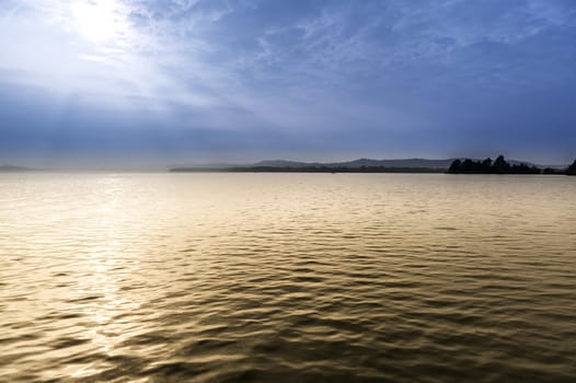 Sunlight and fog in a morning view, Varese lake