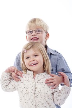 children - portrait of brother and sister standing, holding each other - isolated on white