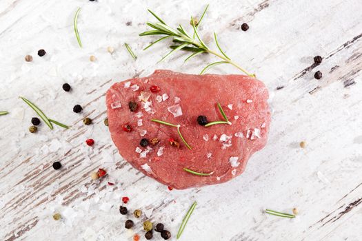 Luxurious raw sirloin steak on white wooden textured background, top view. Culinary red meat eating. 