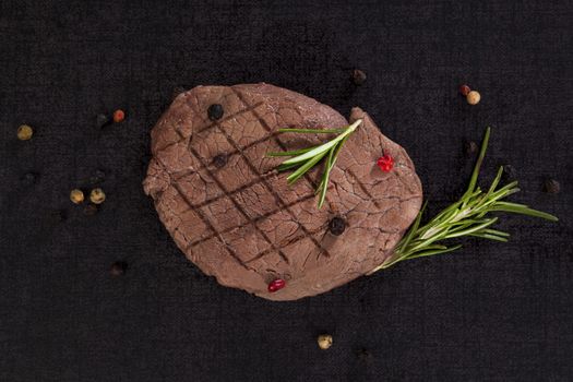 Luxurious rare tenderloin steak with herbs and peppercorn on lava rock. Hot lava rock steak cooking. 
