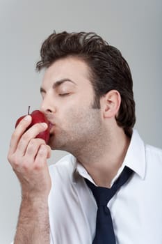 man in white shirt and tie holding red apple - isolated on gray