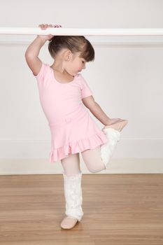 Beautiful little ballet dancer at the dance studio barre