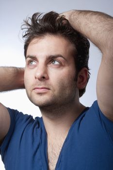 portrait of a man in blue top looking up - isolated on gray