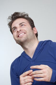 portrait of a man in blue top smiling- isolated on gray