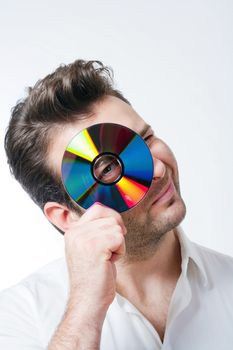 man in shirt standing smiling looking through CD - isolated on white