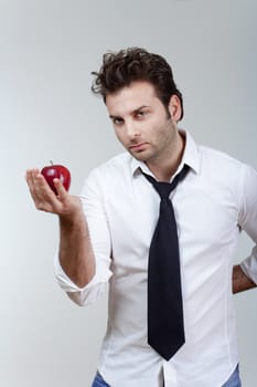 man in white shirt and tie holding red apple looking - isolated on gray