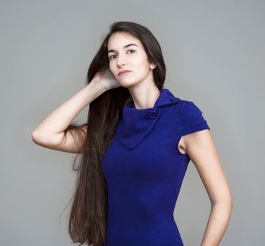 beautiful woman in blue dress with long brown hair - isolated on gray