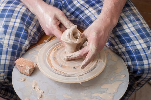 Hands of a potter, creating an earthen jar on the circle