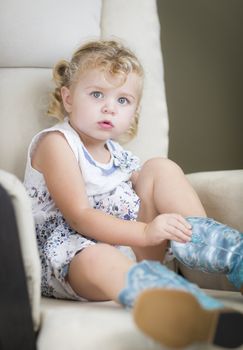 Adorable Blonde Haired Blue Eyed Little Girl Putting on Cowboy Boots.