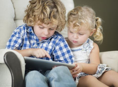 Adorable Young Brother and Sister Using Their Computer Tablet Together.