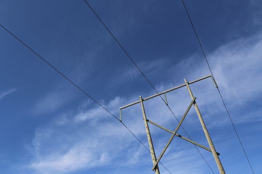 High voltage power transmission lines against blue sky