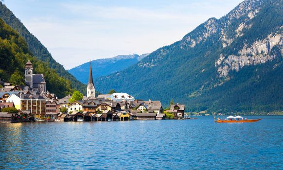 Panoramic view of Hallstatt village with traditional boat on lake, Hallstatt, Austria