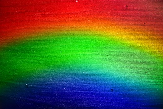 A background in rainbow colors with sand texture