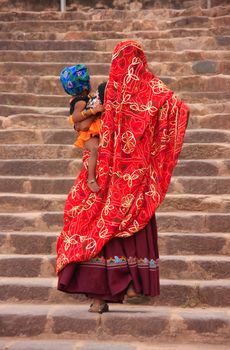 Indian women in colorful saris with a kid walking up the stairs at Ranthambore Fort, Rajasthan, India