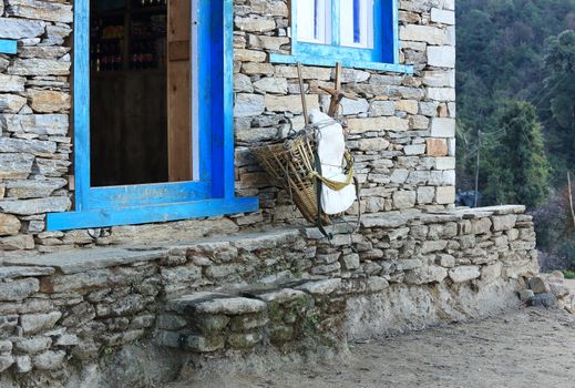 Old wicker basket stands near the brick wall of a traditional house in Everest region, Nepal
