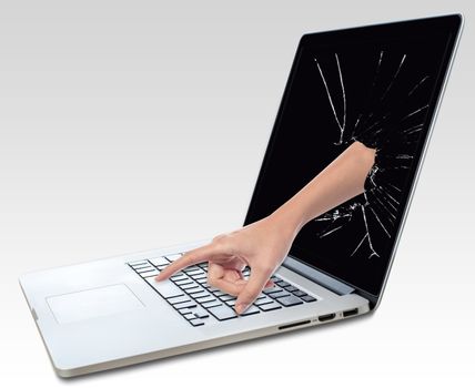 Hand peeping from broken laptop screen presses the button