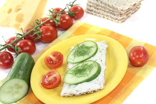 Crispbread with cream cheese, cucumber and dill on a bright background