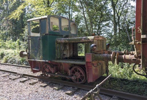 old rusted small green locomotive from train at trainstation hombourg in belgium