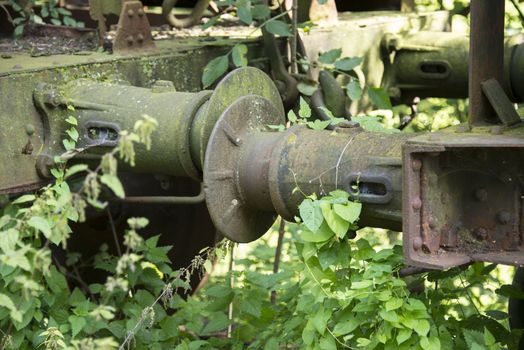 iron old rusted train buffer with green plants overgrown