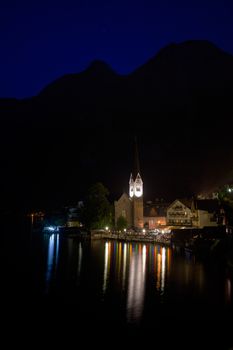Night view of Hallstatt village with Christuskirche church bell tower, Austria