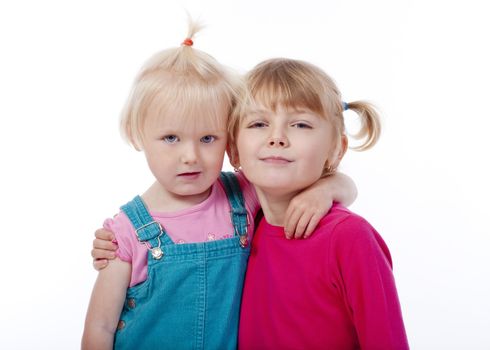 two sisters embracing each other, looking at camera - isolated on white