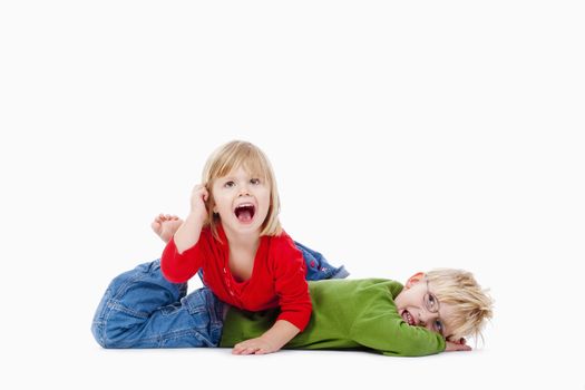 two young siblings fooling around with each other - isolated on white