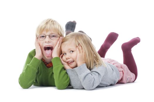 portrait of two young siblings looking at camera, making faces- isolated on white