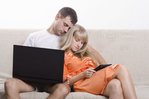 A boy and a girl sitting on the couch. A guy sitting with a laptop, a girl with a tablet. The girl clung. Both fell asleep.