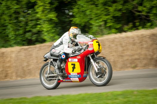 GOODWOOD, UK - JULY 1, 2012: British TV presenter and TT racer Steve Parrish riding the famous Barry Sheene Suzuki moto GP bike on the hill course at Goodwood on July 1, 2012