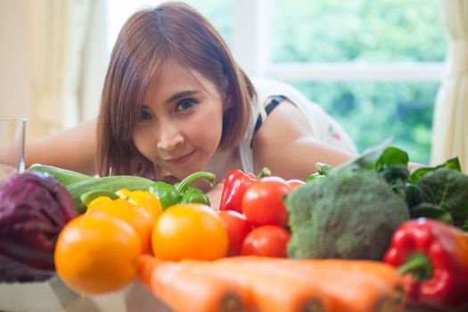 Happy asian woman cooking vegetables green salad in the kitchen