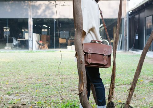 Fashion woman with vintage leather bag, nature background