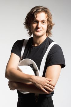 Portrait of a Young Man with Brown Hair Holding a White Hat