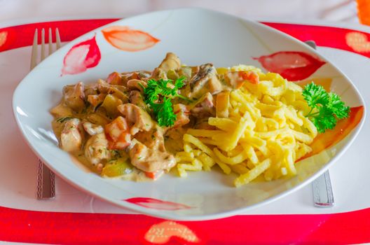 Sliced ​​with pasta on a red white plate