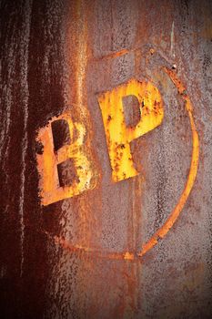 A rusty tank with BP in peeling yellow paint.