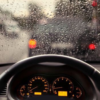 dashboard and rain droplets on car windshield
