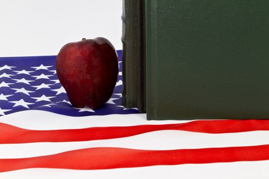 Symbols of learning; schools; and education placed with American flag.; Red apple and hard cover black and green; traditional textbooks with national symbol reflect Board of Education; Core Curriculum; government policy; family values; and critical skills.