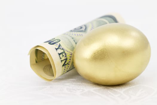 Simple, elegant still life of yen and gold nest egg placed on white damask reflects strong, strategic national attitude toward savings in Japan. 