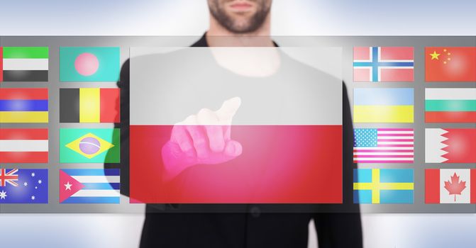 Hand pushing on a touch screen interface, choosing language or country, Poland