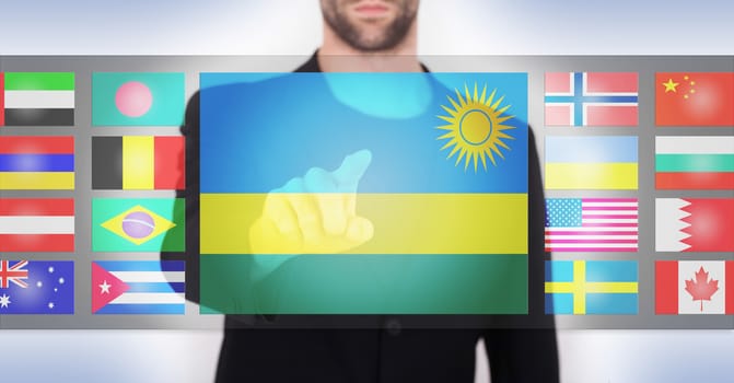 Hand pushing on a touch screen interface, choosing language or country, Rwanda