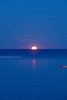 croatia, istria - full moon setting over adriatic sea at dawn