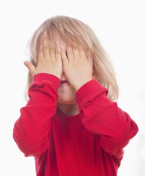 portrait of a boy in red covering his face with hands - isolated on white