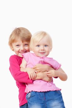 two sisters - older sister carrying the younger one, laughing - isolated on white