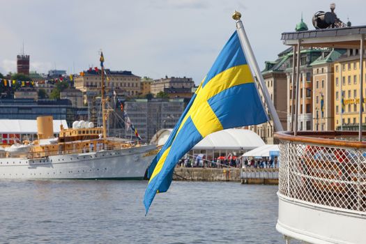 Sweden Stockholm - Swedish flag on one of the many boats anchored at The Old Town - Gamla Stan