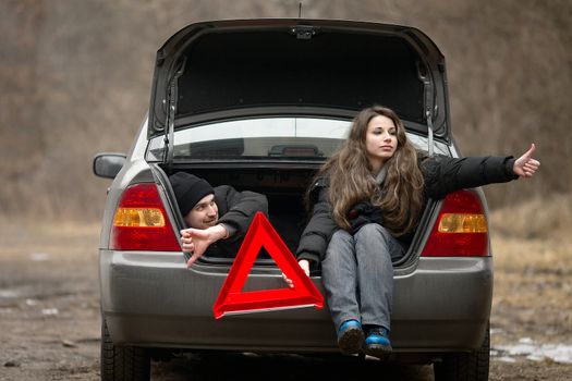 Travelers waiting for assistance in a broken car