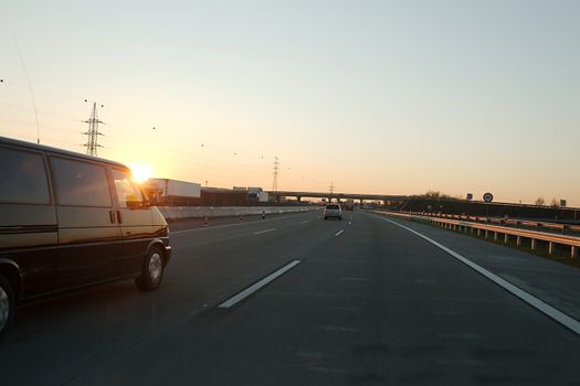 Driving on the highway in the flare of the setting sun