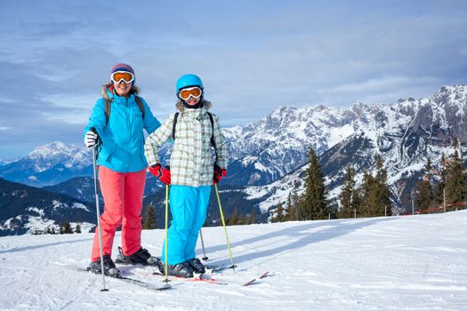 Ski, winter, snow, skiers, sun and fun - Family - mother and daughter enjoying winter vacations.