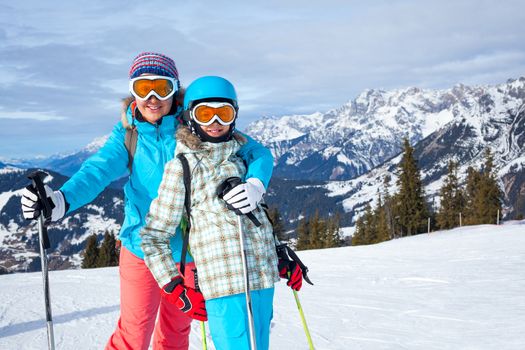 Ski, winter, snow, skiers, sun and fun - Family - mother and daughter enjoying winter vacations.