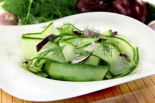 a bowl of cucumber salad with dill and red onions