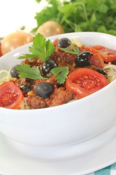 Spaghetti alla puttanesca with parsley on light background